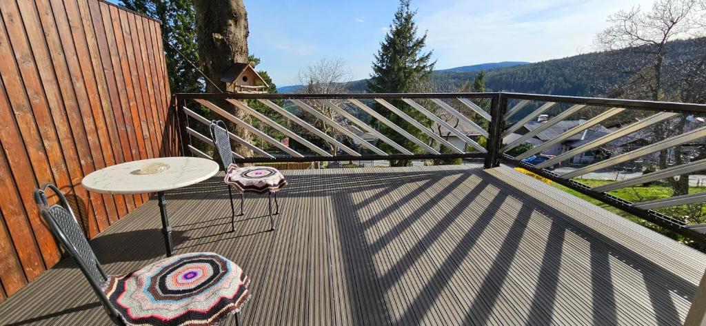 a deck with a table and chairs on a balcony at Hütte auf 1000m Höhe in Mönichkirchen. in Mönichkirchen
