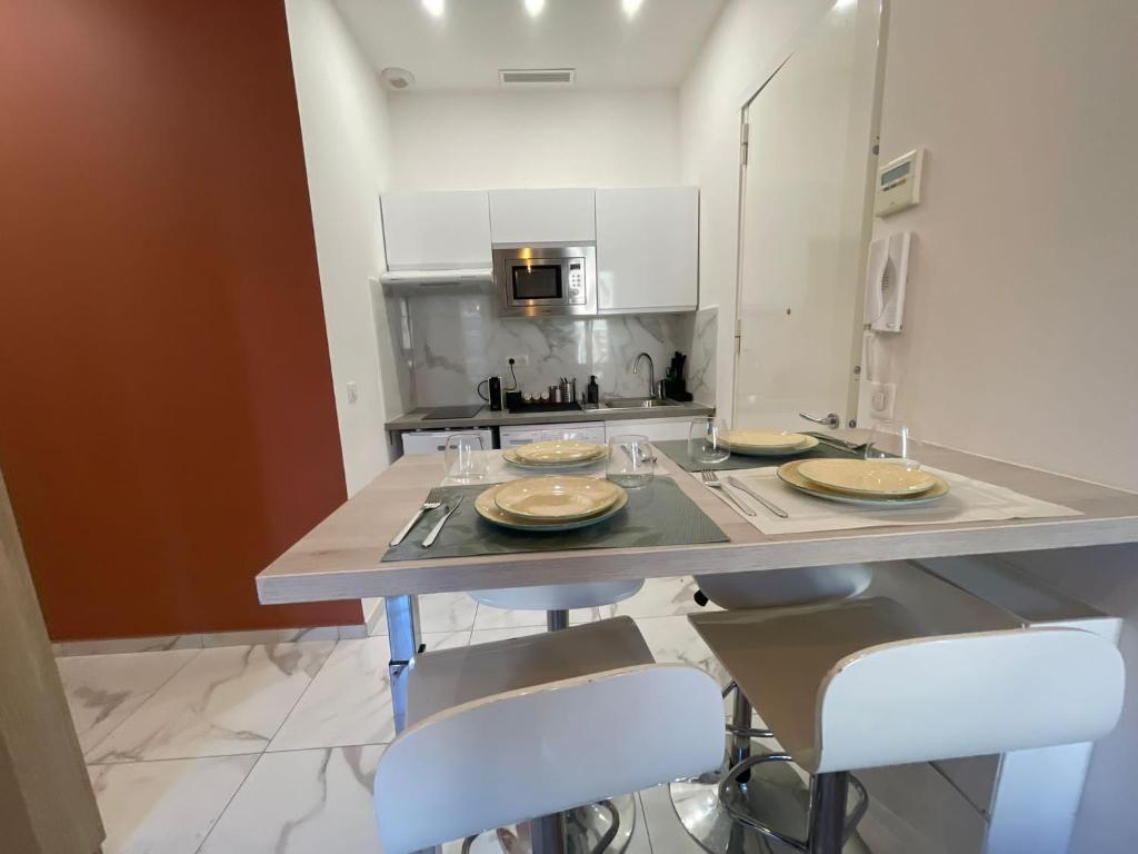 d'une cuisine avec un comptoir avec trois assiettes. dans l'établissement Appartement centre ville, à Nice