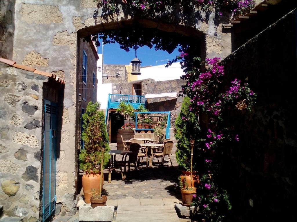 サンミゲル・デ・アボナにあるHotel Rural 4 Esquinasの- パティオ(テーブル、花付)への入り口