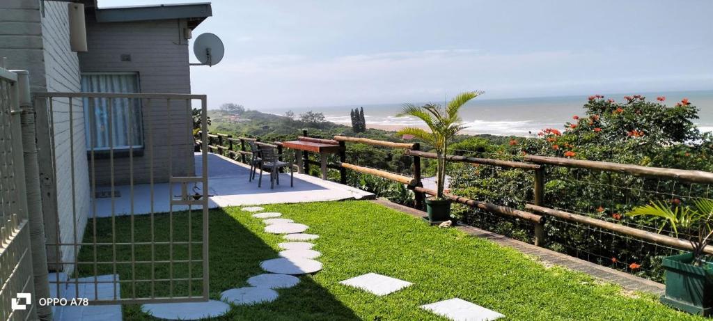 a backyard with a view of the ocean at Tugela Mouth Sea View Guest House (Sleeps 8) in Tugela Mouth