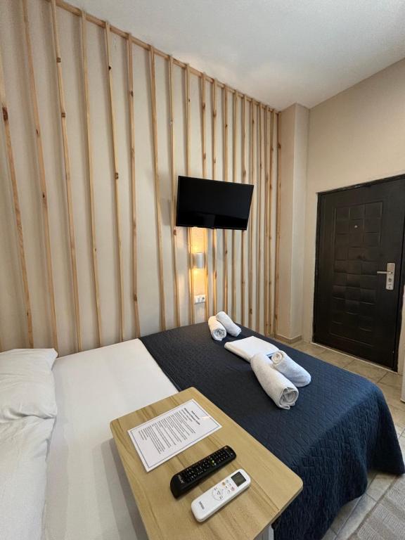 Habitación de hotel con cama y mesa con mando a distancia en Athanias Studio en Drama