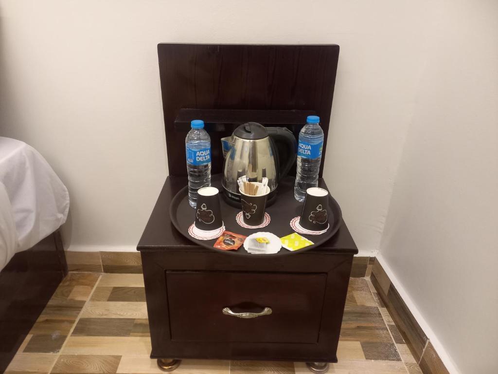 a table with a tea kettle and water bottles on it at Basha Pyramids inn in Cairo