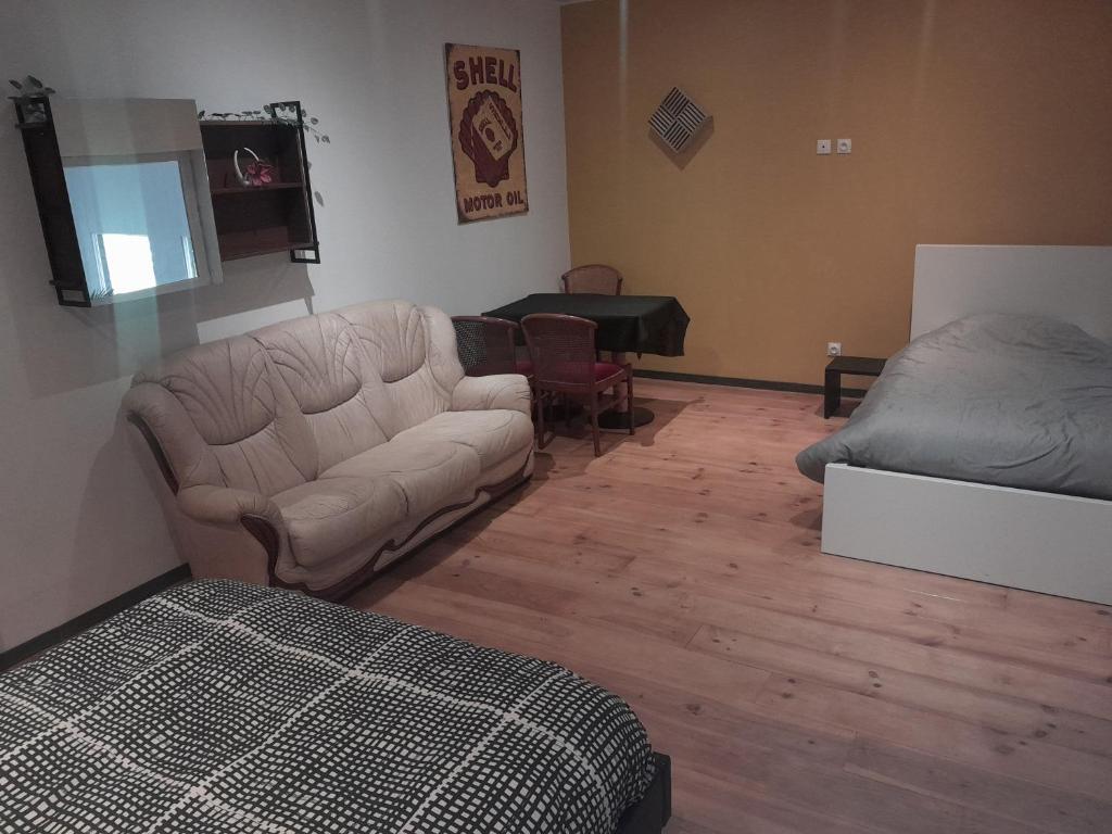 un soggiorno con divano e letto di chambre zen a Condé-sur-Noireau