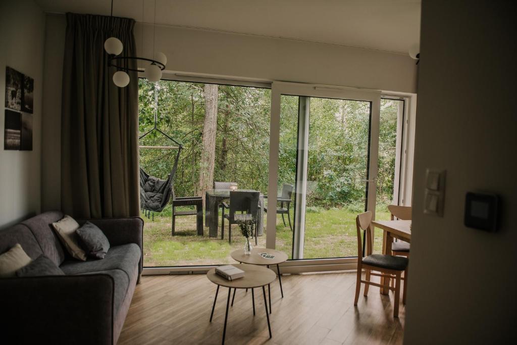 ein Wohnzimmer mit einem Sofa und einem Tisch in der Unterkunft Sam Las Apartamenty Białowieża in Białowieża