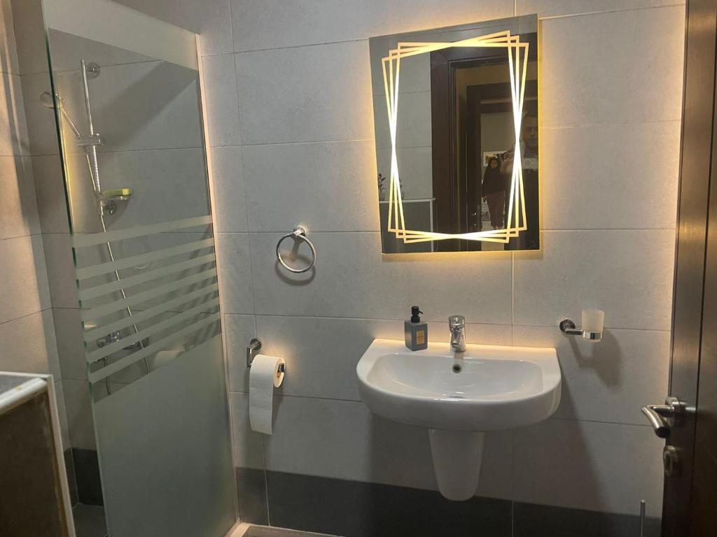ein Bad mit einem Waschbecken und einem Spiegel in der Unterkunft Abdoun apartment in Amman