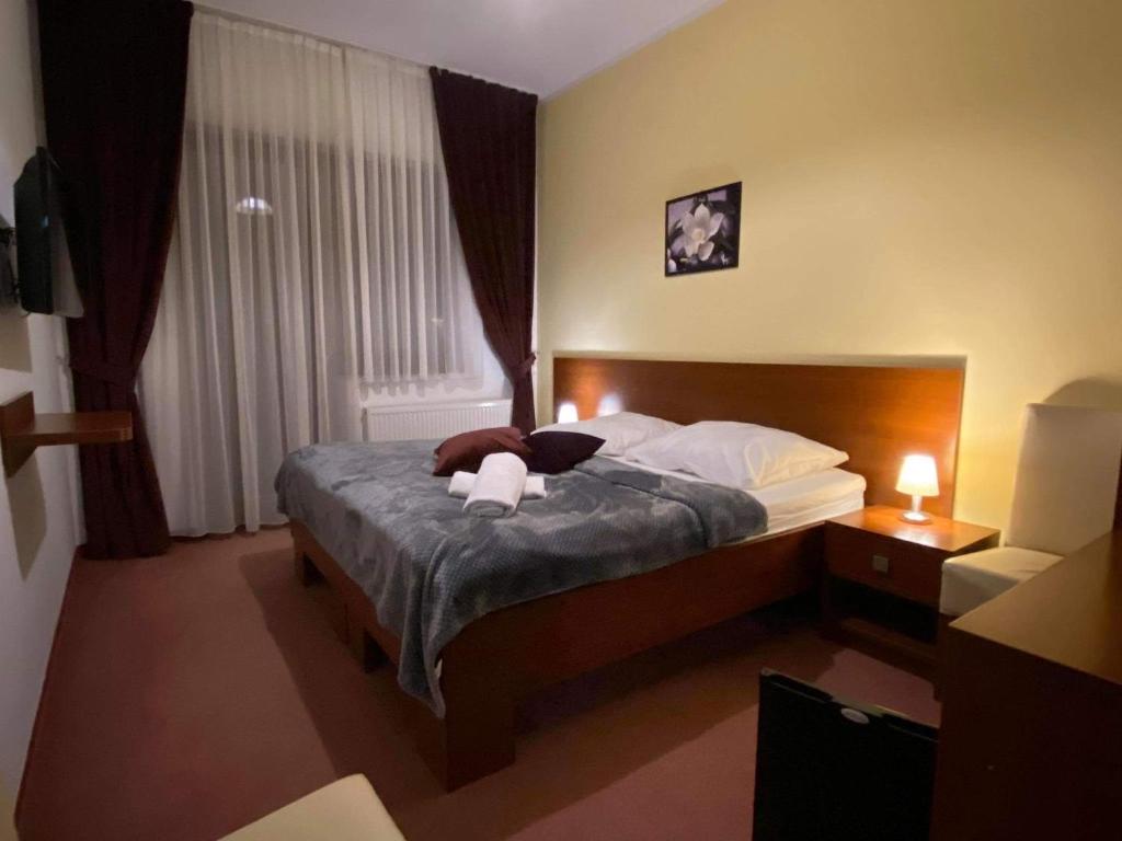 a hotel room with a bed with two towels on it at Willa Stożek, 50 m od term i wyciągów narciarskich in Białka Tatrzanska