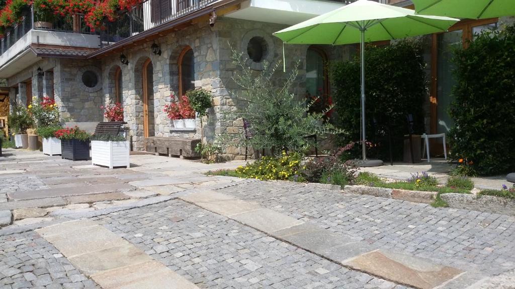 a cobblestone street with an umbrella in front of a building at La Stella delle Alpi in Vico Canavese