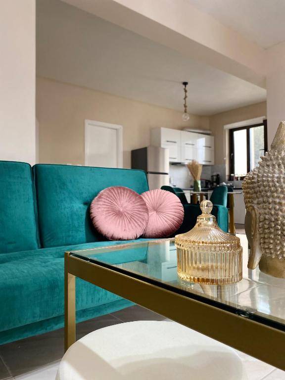 a living room with a blue couch with pink pillows at Mons Apartments in Spílion