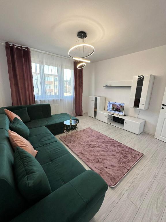 a living room with a green couch and a tv at Apartament pe pietonala nr1 in Hunedoara