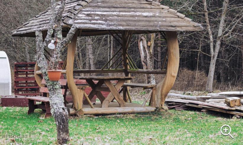 einen hölzernen Pavillon mit einem Picknicktisch im Gras in der Unterkunft Pailseti Dzukijos gamtoje in Paliepis
