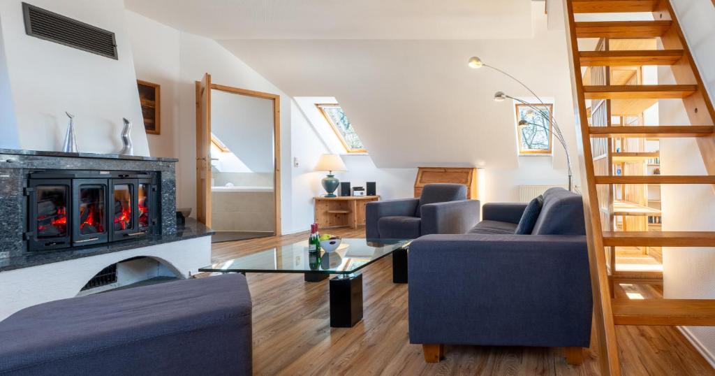 uma sala de estar com lareira e cadeiras azuis em Bussard em Zinnowitz
