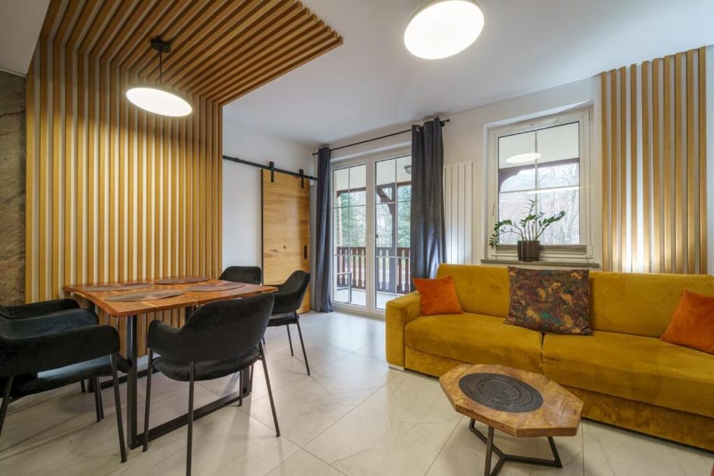 sala de estar con sofá amarillo y mesa en Apartament Agat H2 z prywatną SAUNĄ - Mountain Aparts, en Świeradów-Zdrój