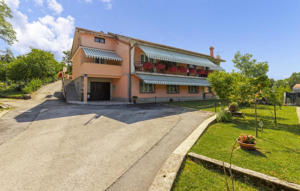 ein großes Haus mit einer Einfahrt davor in der Unterkunft Apartman Nora in Mučići