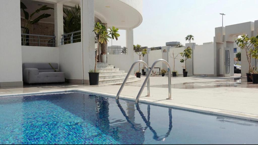 a swimming pool in front of a building at PRIVATE ROOM WITH WASHROOM AND BALCONY in Dubai