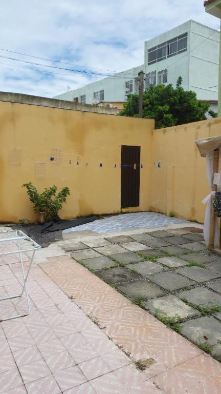 a yellow wall with a door and a building at Casa no centro de Saquarema in Saquarema