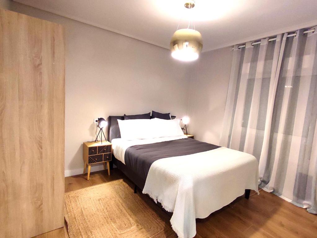 a bedroom with a bed with a black and white blanket at Sweet Aviles Apartamento in Avilés