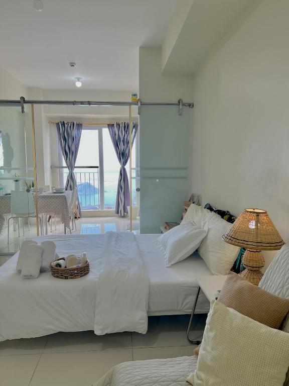 a bedroom with a large bed with a view of the ocean at Lake View Wind SMDC Tagaytay in Tagaytay