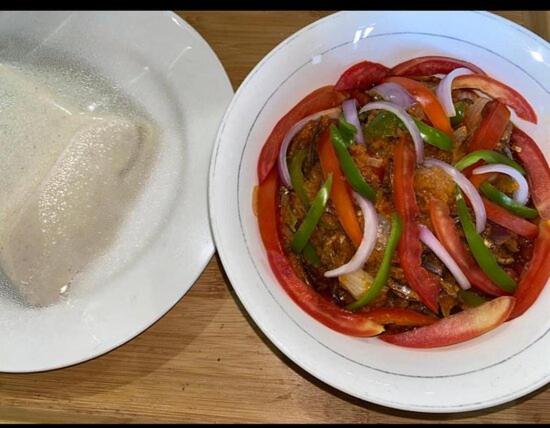 un tazón de comida con pimientos y cebollas en una mesa en EL ELOLO Hotel, en Dzake