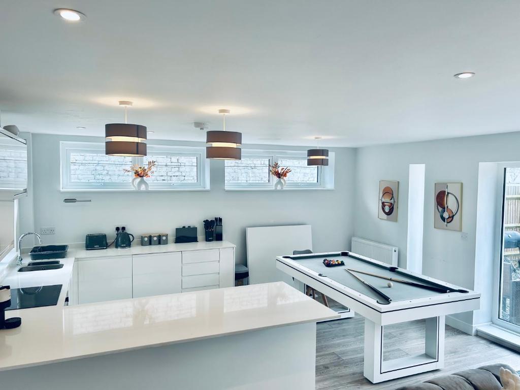uma cozinha com armários brancos e uma mesa branca em Luxury Town Centre House, Faversham em Faversham