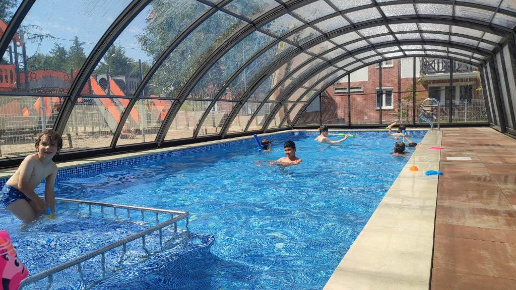 a group of people swimming in a swimming pool at Baśniowy apartament in Sztutowo