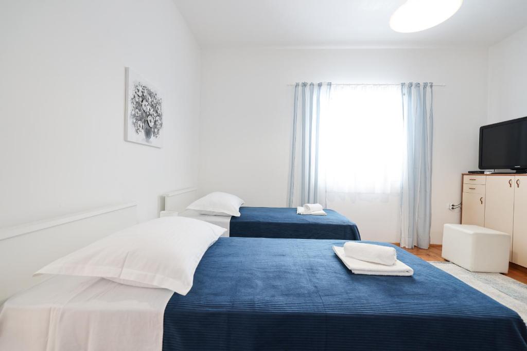 a bedroom with two beds with blue and white sheets at One bedroom apartment Dragica in Zadar