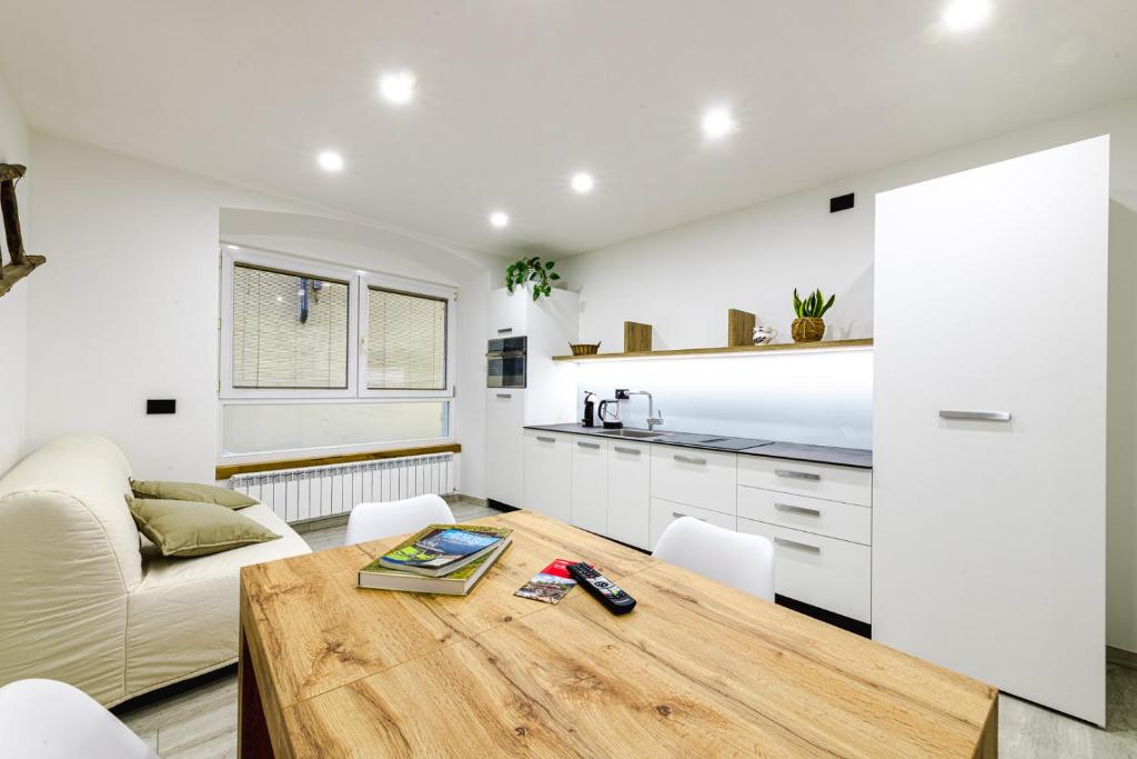 a kitchen and living room with a wooden table at Appartamento San Carlo in Tirano