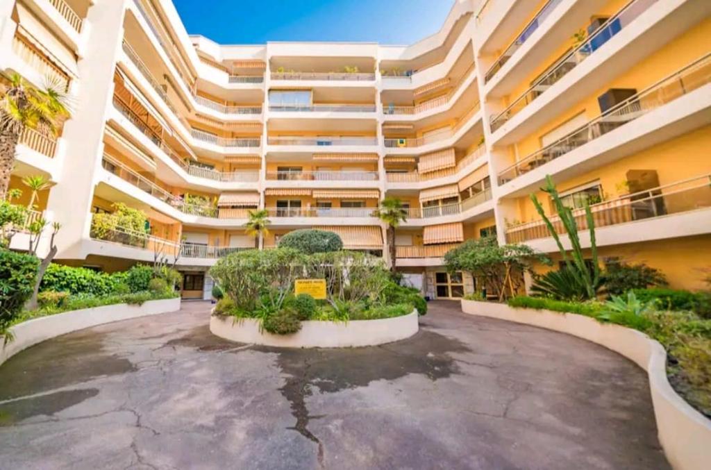a large apartment building with a courtyard with plants at Princess Palace Beach Monte-Carlo in Monte Carlo