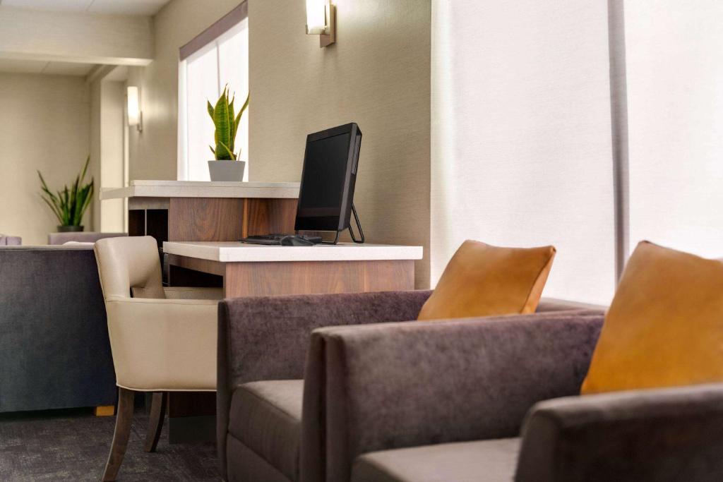 a waiting room with couches and a computer on a desk at La Quinta Inn by Wyndham Waldorf in Waldorf