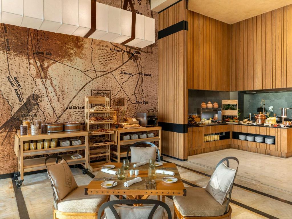 a restaurant with a map on the wall at Alwadi Hotel Doha - MGallery Collection in Doha