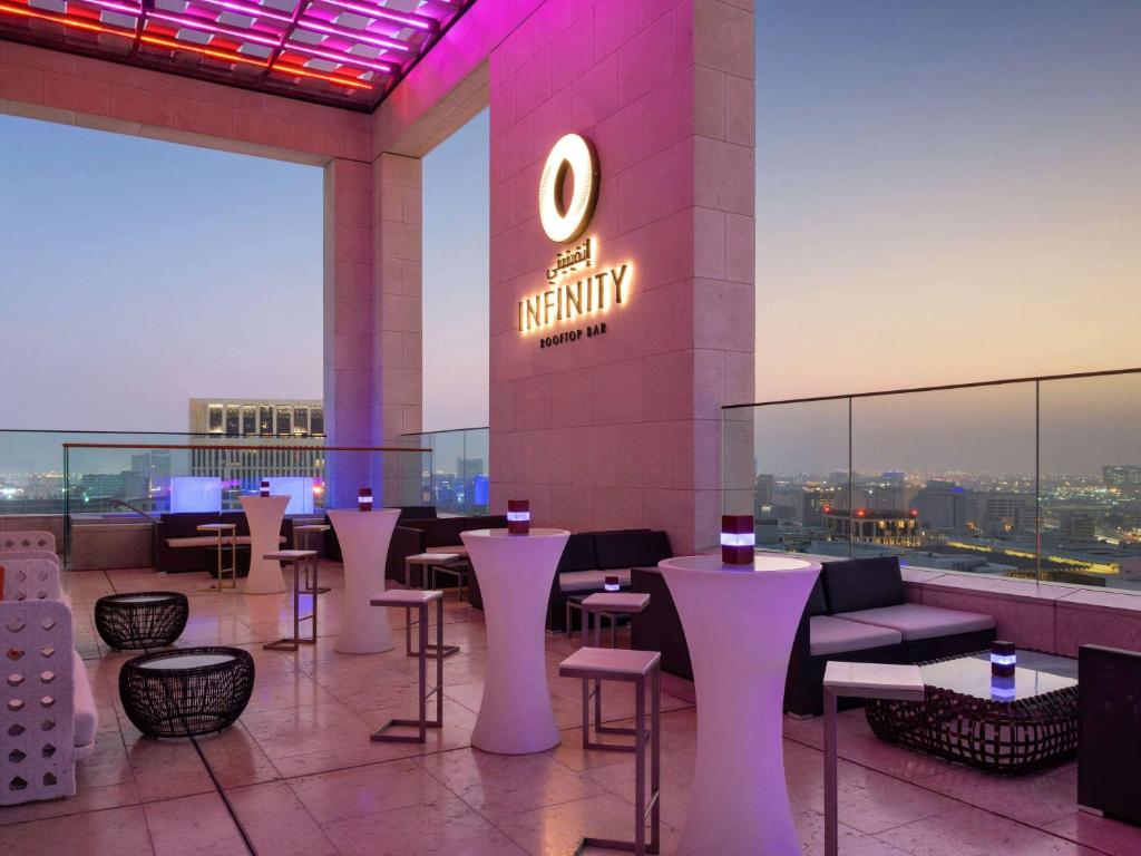 a restaurant with tables and chairs on a building at Alwadi Hotel Doha - MGallery Collection in Doha