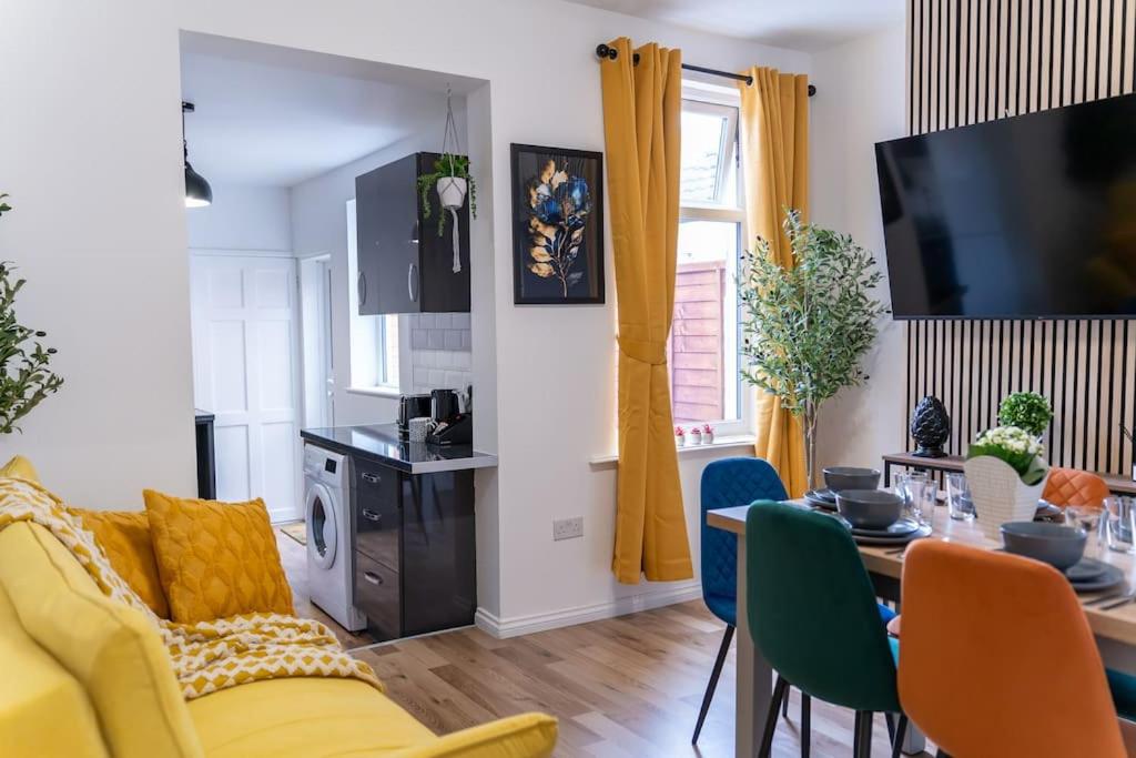 a living room with a yellow couch and a table at Open Mind Property - Luxury 5 Beds & Free Parking in Portsmouth
