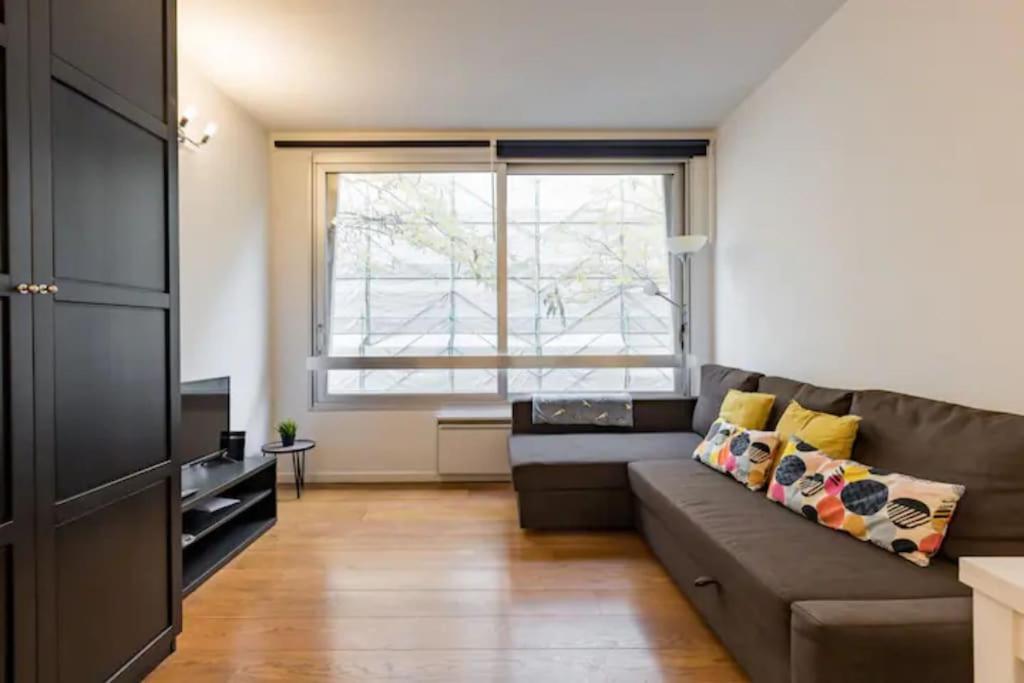 a living room with a couch and a window at Appartement à Bruxelles in Brussels