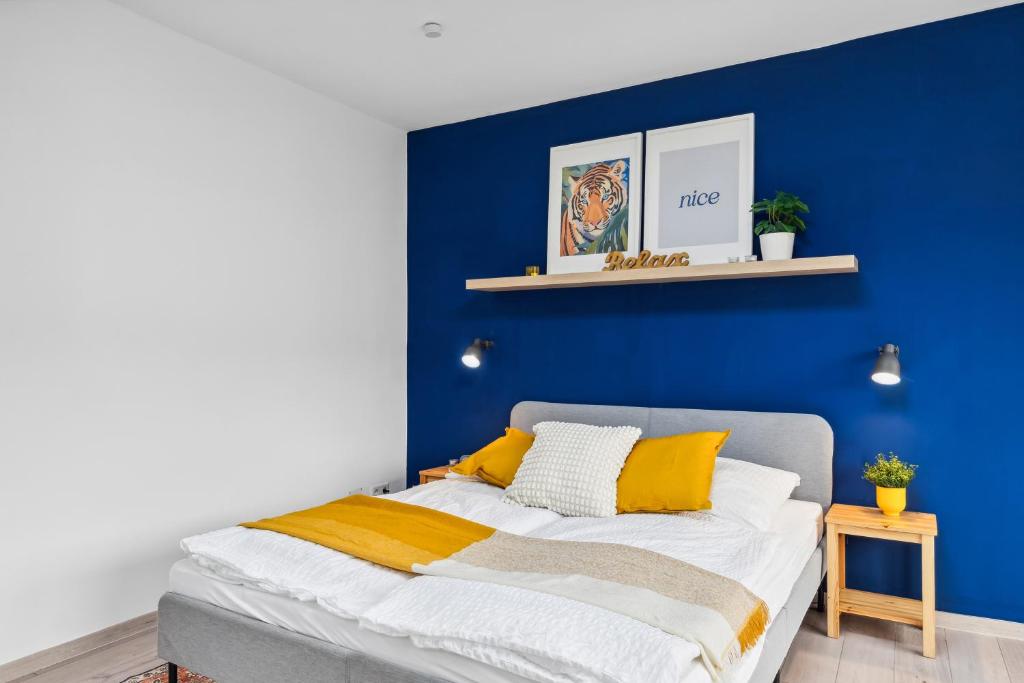 a blue bedroom with a bed with yellow pillows at Moderne, Zentrale und Gemütliche Unterkunft in Koblenz