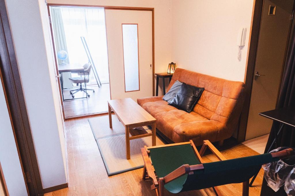 a living room with a couch and a table at 寄道アパート高松東インターチェンジ店201 最大5名1戸貸切 無料駐車場 in Kawashima