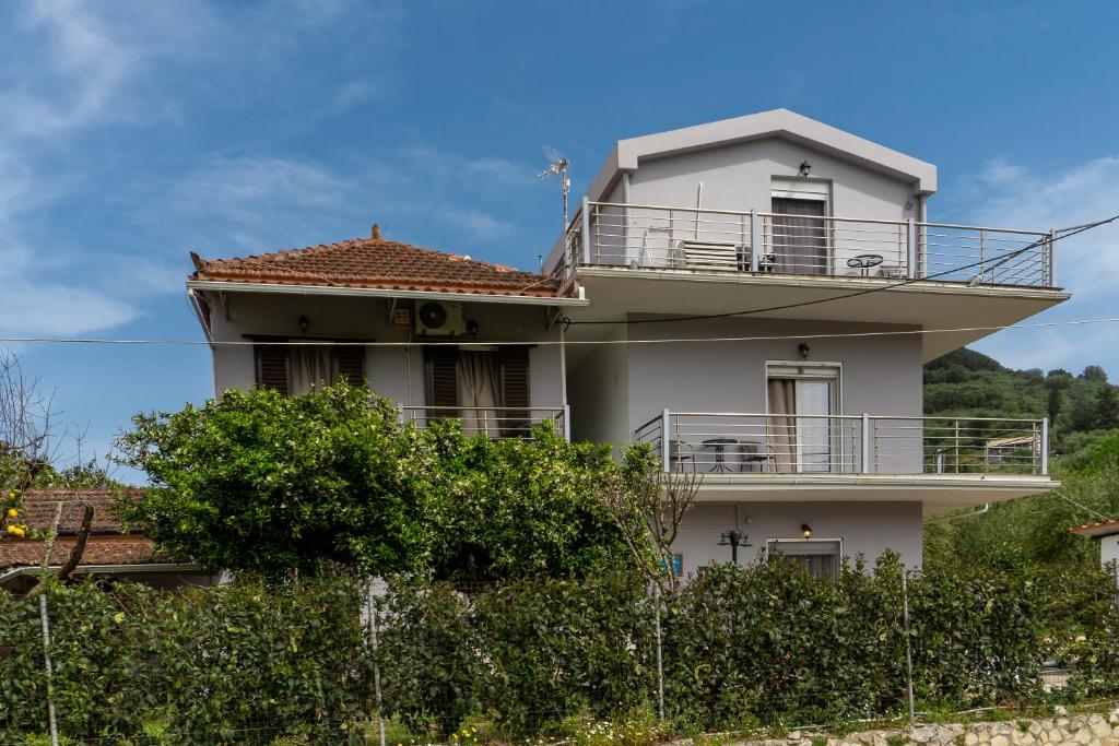 a white house with a balcony on top of it at potami appts in Áno Yerakaríon