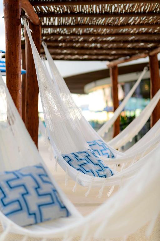 a couple of white hammocks sitting on a beach at Hilton Cancun Mar Caribe All-Inclusive Resort in Cancún