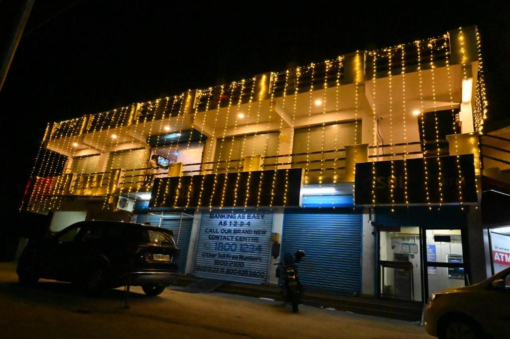 a building with christmas lights on the side of it at GR INN in Maraiyūr