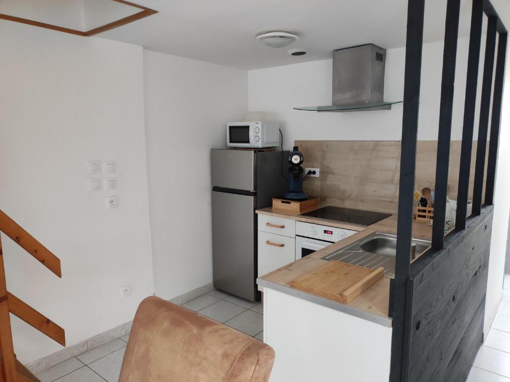 a small kitchen with a sink and a refrigerator at La petite trapue in Desvres