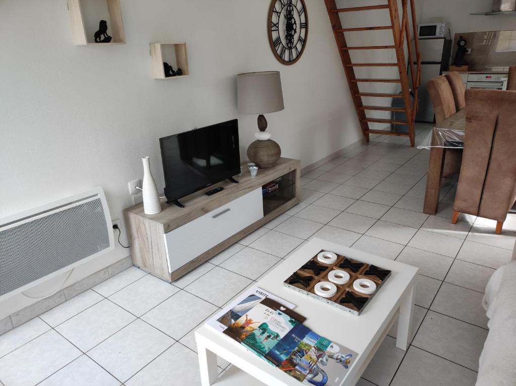 a living room with a tv and a coffee table at La petite trapue in Desvres