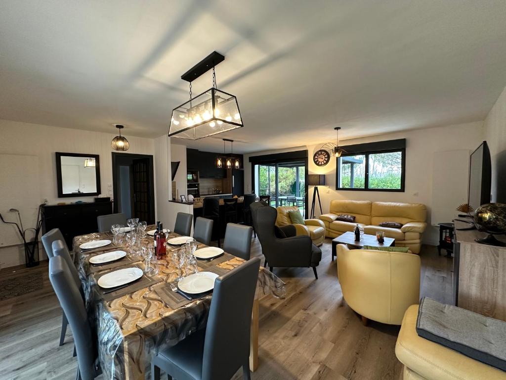 une salle à manger et un salon avec une table et des chaises dans l'établissement Villa pour des vacances en famille (linge inclus), aux Mathes