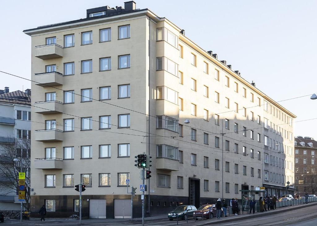 un edificio blanco alto en una calle de la ciudad en Valoisa huoneisto, loistavalla sijainnilla!, en Helsinki