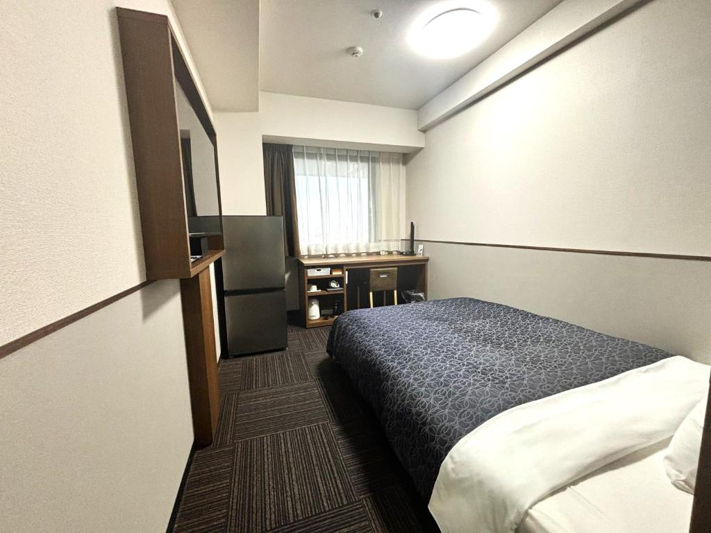 a hotel room with a bed and a desk at Hotel 1-2-3 Kurashiki in Kurashiki
