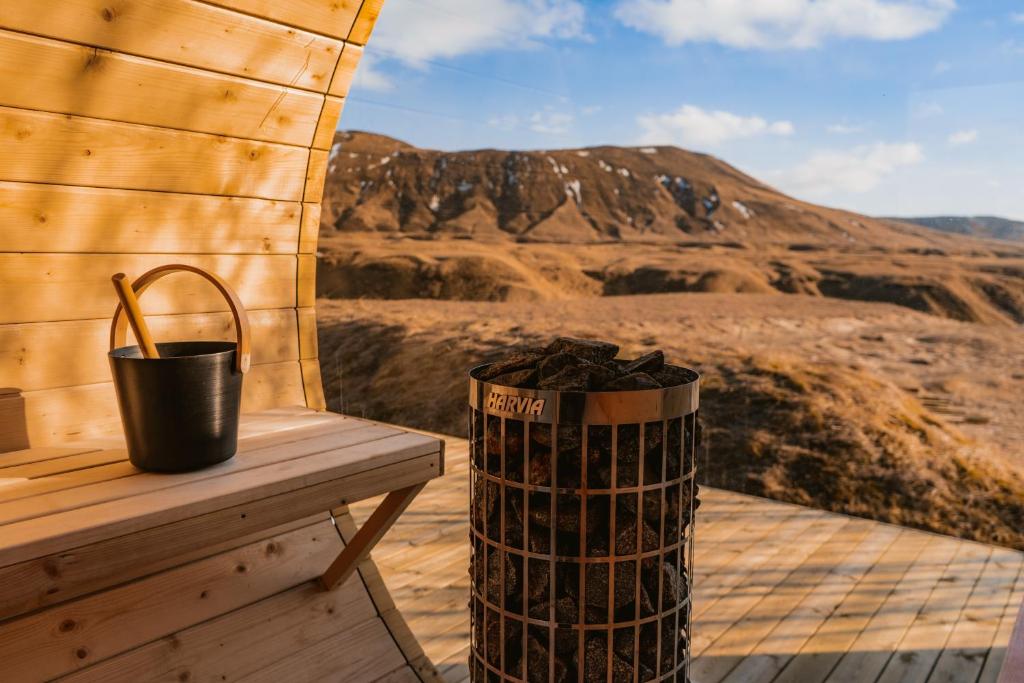 a trash can sitting on a bench next to a mountain at Tindasel Lodge in Hella