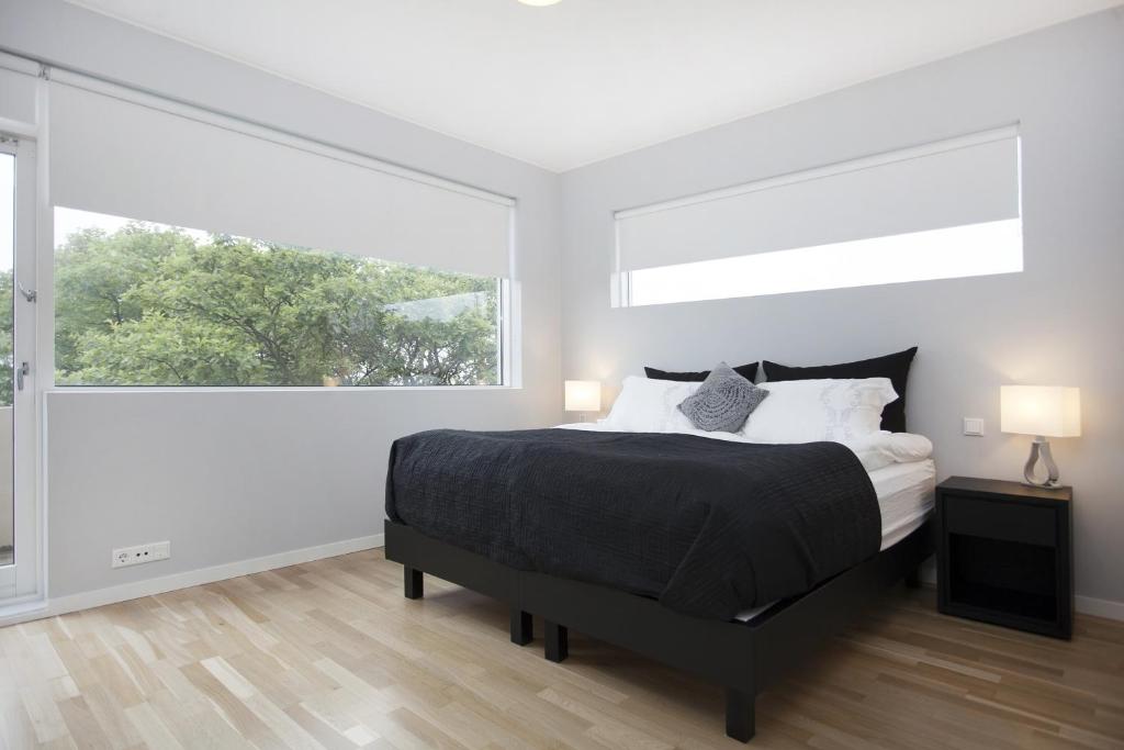 a bedroom with a bed and a large window at Blue Luxury Apartments in Reykjavík