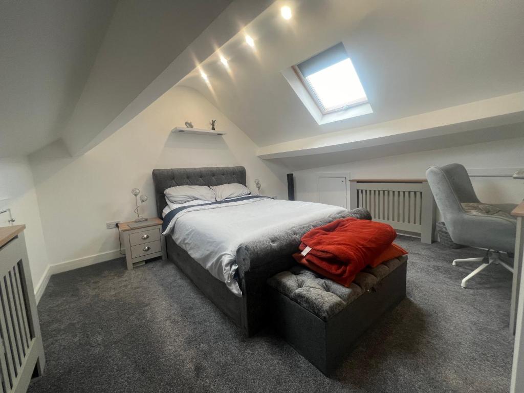 a bedroom with a bed and a chair and a window at Tredegar property, unique location with luxury bedroom, bathroom & dining room in Sirhowy