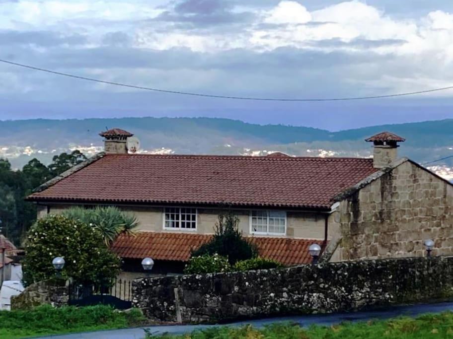 ein Haus mit einer Steinmauer davor in der Unterkunft Casa Crisa in Marín