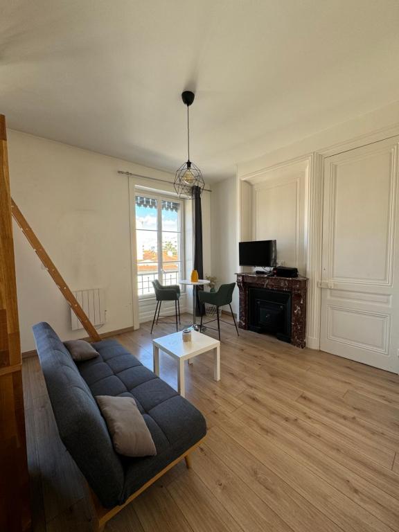 ein Wohnzimmer mit einem Sofa und einem Tisch in der Unterkunft Studio hypercentre Tassin La Demi Lune in Tassin-la-Demi-Lune