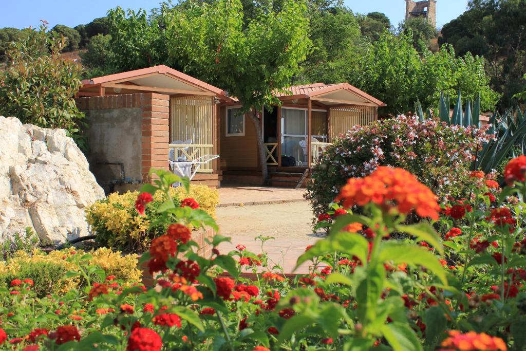 a house with a bunch of flowers in front of it at Camping Roca Grossa in Calella