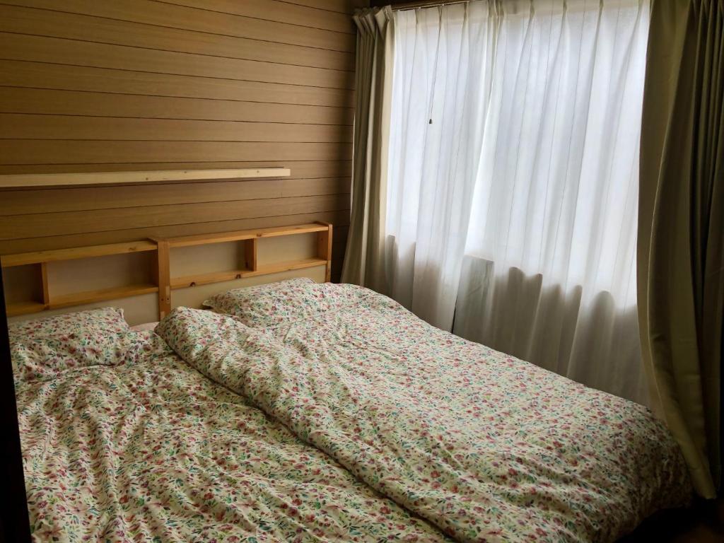 Mitoyo的住宿－Setouchi base - Vacation STAY 48143v，卧室内的一张床位,配有窗帘和窗户