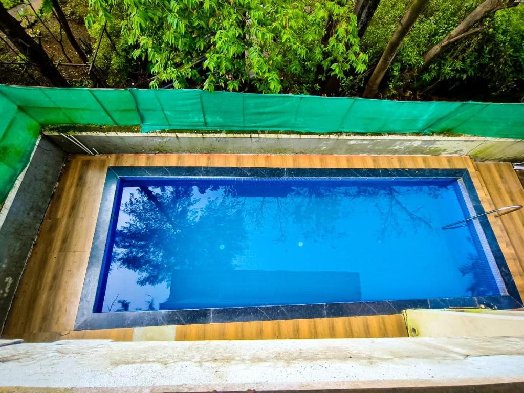 a swimming pool in a house with trees in the background at MERCURY VILLA ll 4BHK ll PRIVATE SWIMMING POOL in Lonavala